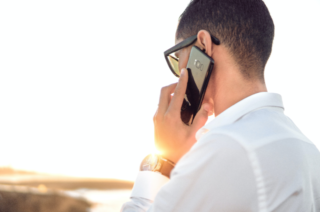 man talking on phone on beach