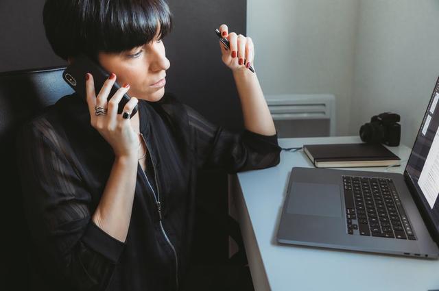 woman talking on phone with laptop