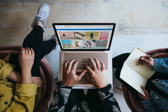 three people sitting and working on laptop