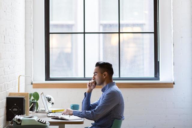 man sitting at desk working on laptop