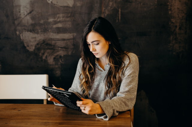 woman sitting at desk working on tablet