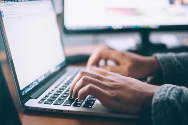 two hands typing on laptop computer