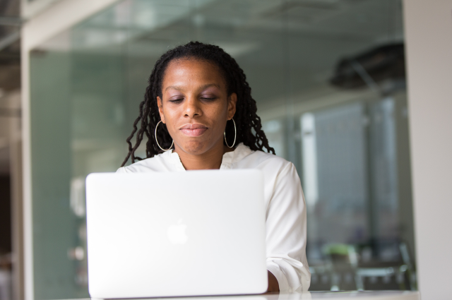 Business woman sitting at laptop computer typing