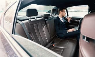 Business leader working from car on his computer using ChatGPT, GPT-3 chatbot
