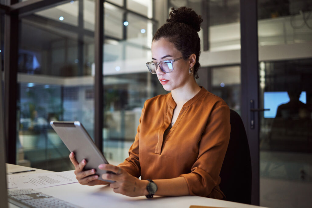 Businesswoman looking at tablet reviewing what the difference is between GA4 vs. universal analytics