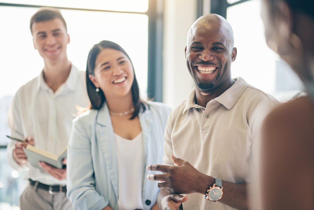 Group of diverse workers stand talking together sharing their multicultural perspectives