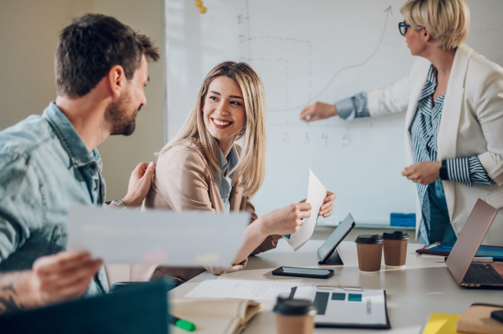 Three business people sit brainstorming about the benefits of their business offering