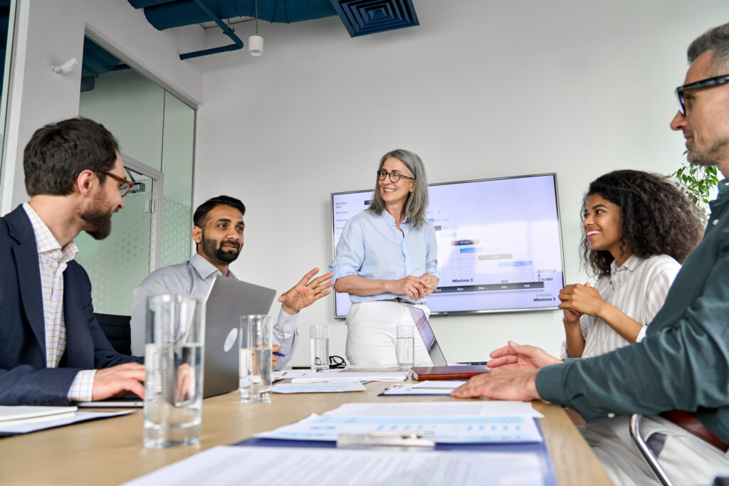 Group of business people meet around a conference table to talk about their AI sales strategy