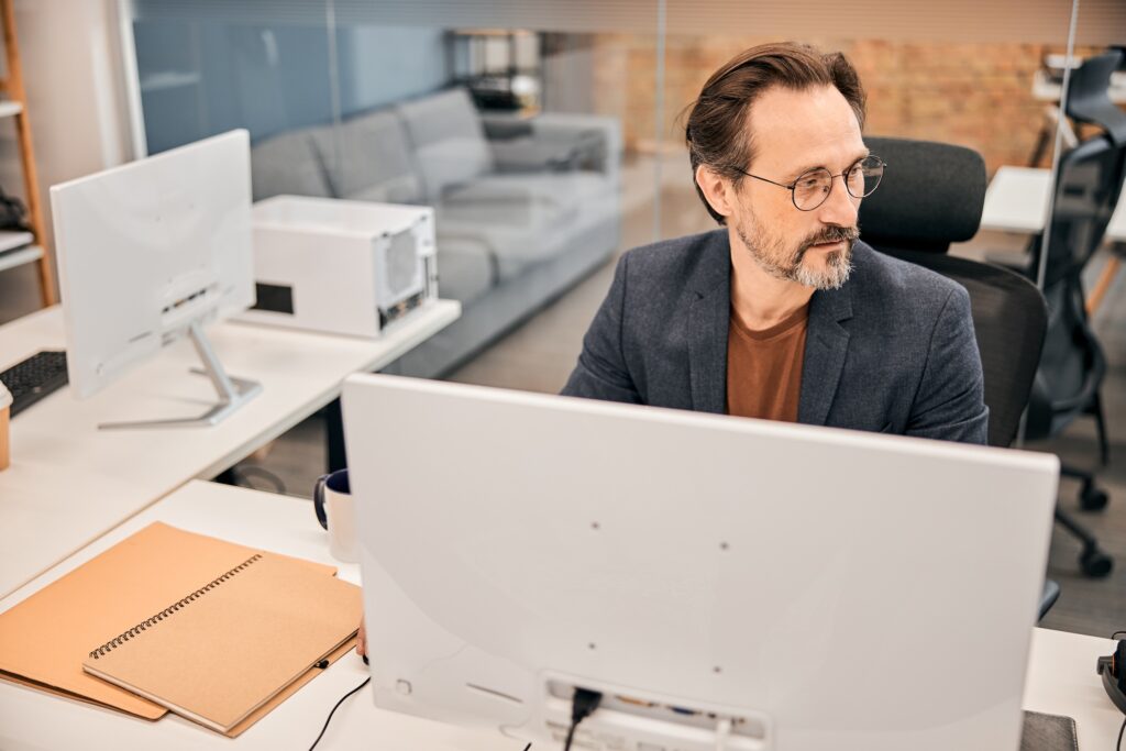 Business professional sits at computer reviewing website performance for web search optimization