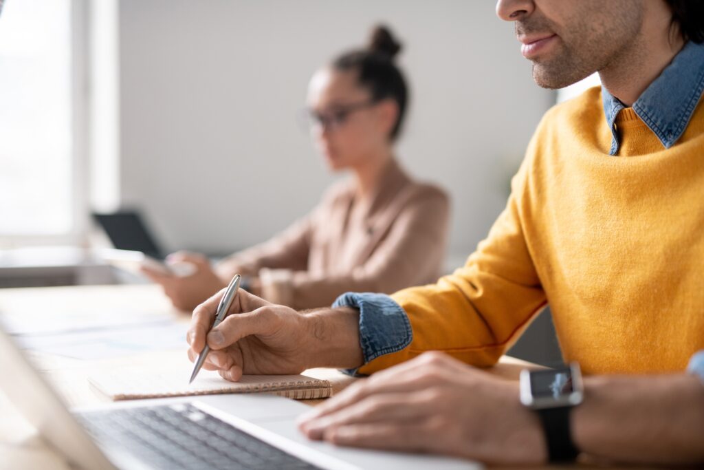 two business people sit at a desk on their devices working on B2B lead generation trends