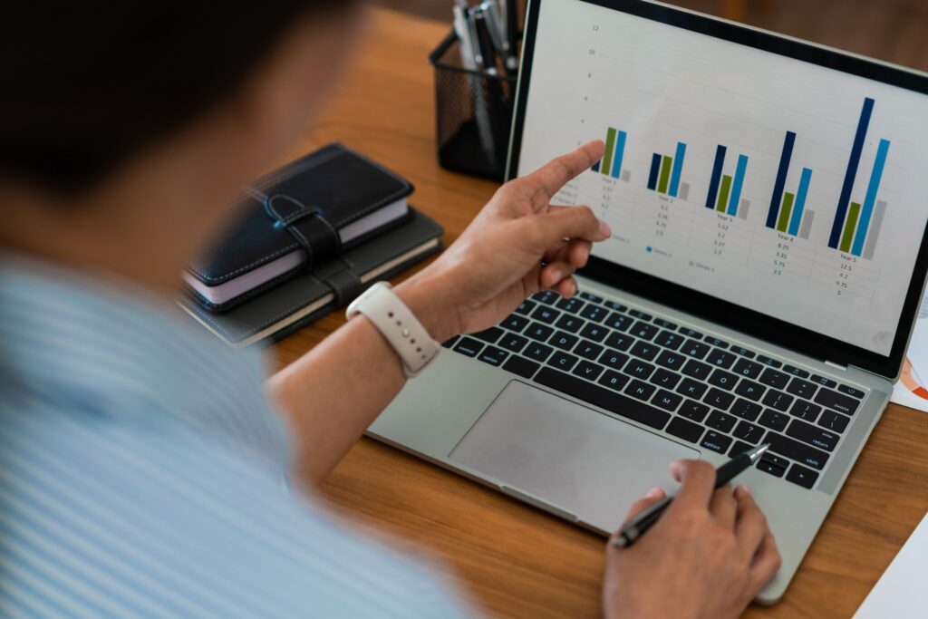 Businessman sits at a desk looking at laptop screen showing data from SEO and lead tracking