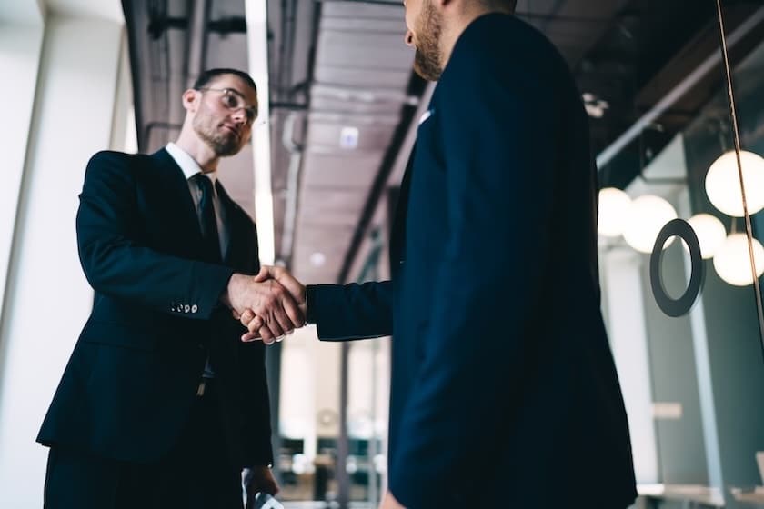 two businessman shake hands at the close of a deal at the end of the B2B funnel