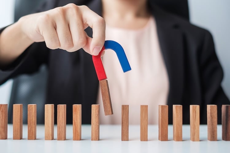 Businesswoman's hand holding a magnet symbolizing B2B lead magnets