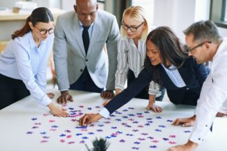 group of professionals leans over a conference table debating about the right B2B marketing strategy framework