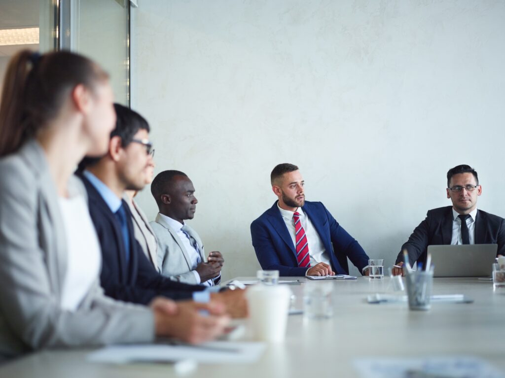 Sales leaders sit around a conference table with prospects in a sales pitch meeting and confront B2B sales objections