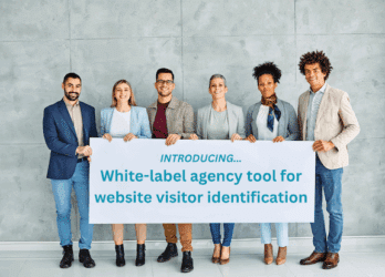 Group of businesspeople stand together looking at the camera, holding a sign about LeadLander's new white-label agency tool for website visitor identification