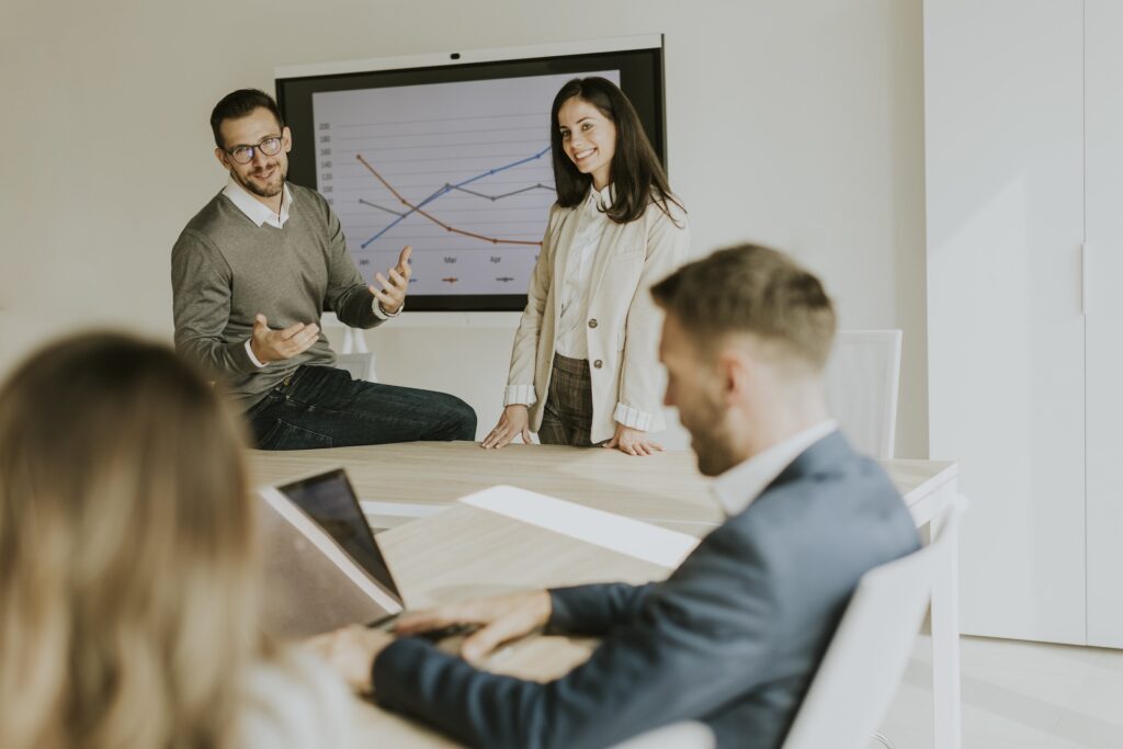 Group of marketing and sales professionals sit around a conference table discussing customer intent data